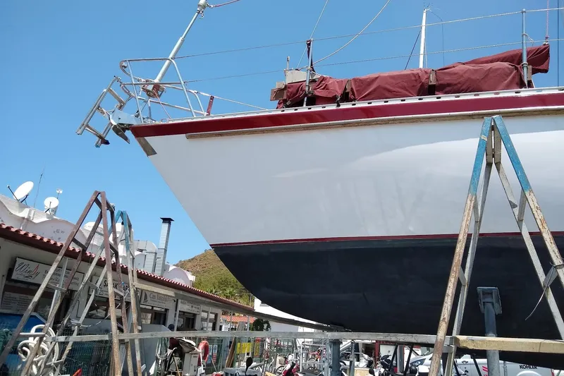 Slide: The Image of 1988 Tayana Vancouver 42 sailboat on dry dock, undergoing maintenance under clear blue sky. - 9