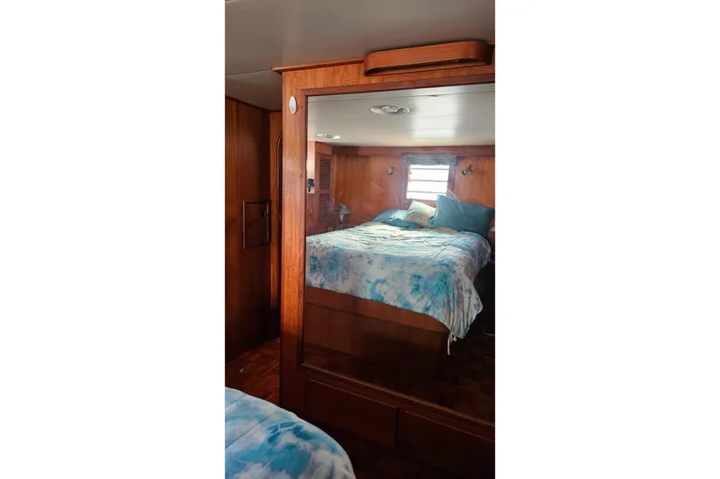Slide: The Image of Cozy bedroom interior of 1985 CHB 48 Motor Yacht with wooden accents and blue bedding. - 59