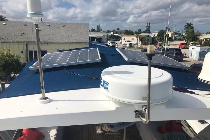 Slide: The Image of 1985 CHB 48 Motor Yacht with solar panels on the roof, docked in a marina. - 6