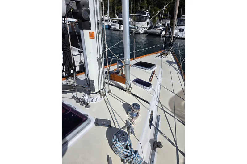 Slide: The Image of Sailboat deck view of 1986 Cambria 46, featuring rigging and winches in a marina. - 10