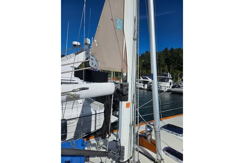 Slide: The Image of 1986 Cambria 46 sailboat mast and rigging in a marina setting. - 11