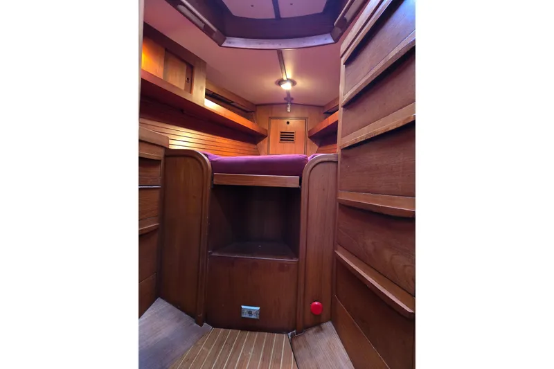 Slide: The Image of Interior of 1986 Cambria 46 sailboat with wooden cabinetry and cozy sleeping area. - 21