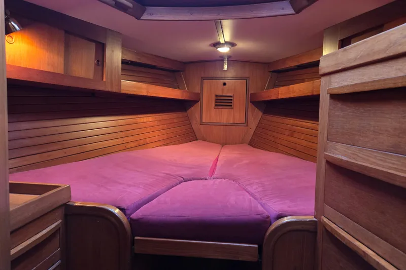 Slide: The Image of Cozy wooden cabin interior of 1986 Cambria 46 sailboat with pink bedding. - 22
