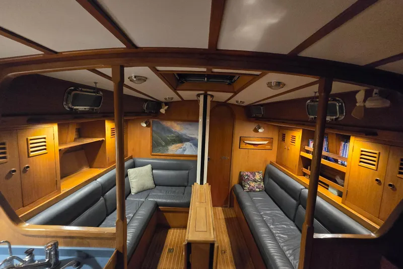 Slide: The Image of Interior of 1986 Cambria 46 yacht with wooden furnishings and blue seating. - 24
