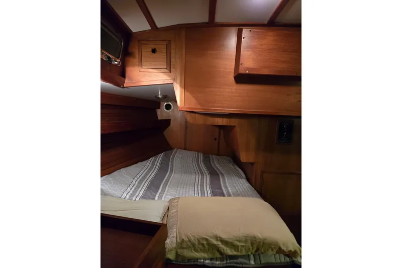 Slide: The Image of Cozy wooden cabin interior of 1986 Cambria 46 sailboat with bed and storage. - 31