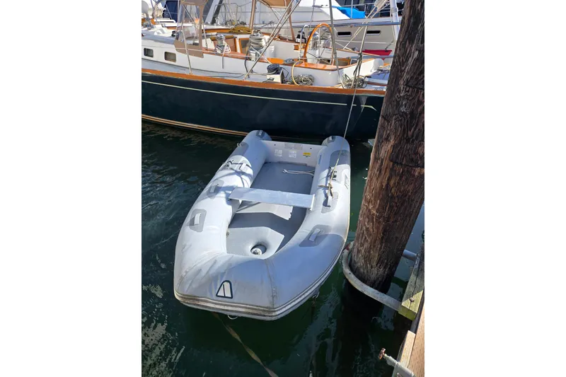 Slide: The Image of Inflatable dinghy moored beside a 1986 Cambria 46 sailboat at a dock. - 38