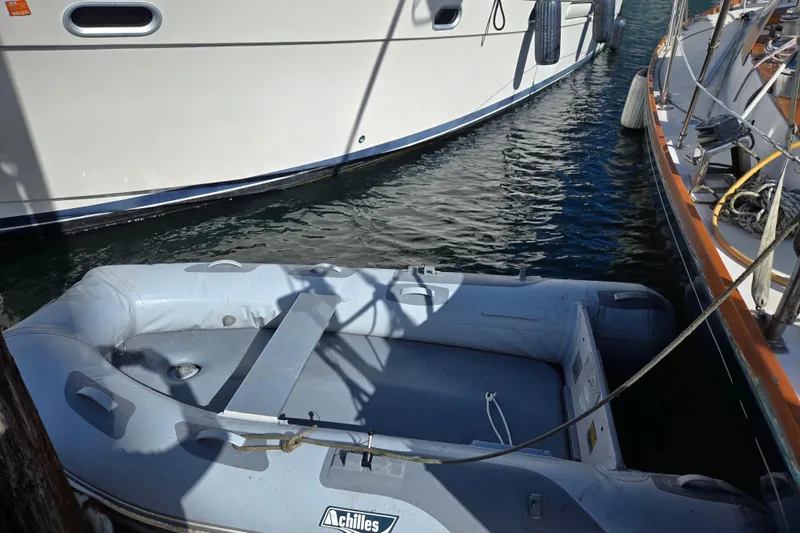 Slide: The Image of Inflatable dinghy moored between boats, near a 1986 Cambria 46 yacht. - 39