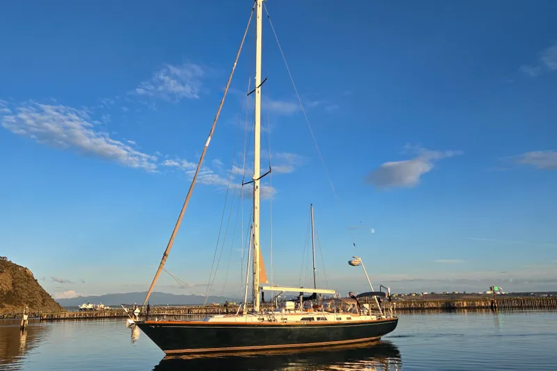 Slide: The Image of Sailboat Cambria 46, 1986 model, on calm water under a clear blue sky. - 4