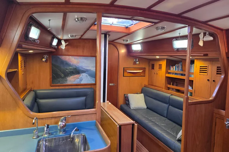 Slide: The Image of Interior of 1986 Cambria 46 yacht with wood paneling and blue seating. - 7