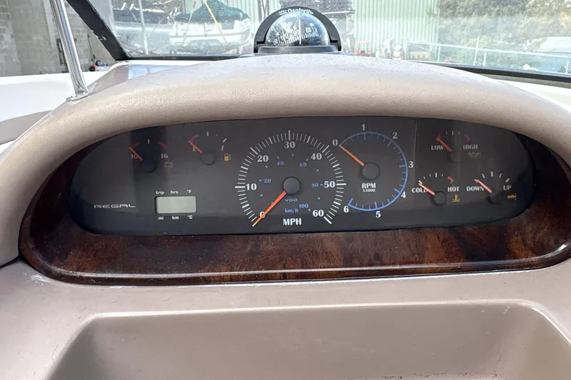 Slide: The Image of Dashboard of a 2002 Regal 2400 Bowrider boat with speedometer and gauges. - 11
