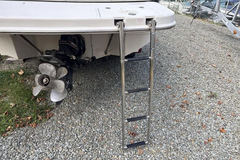 Slide: The Image of Rear view of a 2002 Regal 2400 Bowrider with ladder and propeller on gravel. - 15
