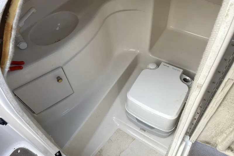 Slide: The Image of Interior of a 2002 Regal 2400 Bowrider boat with a portable toilet. - 16