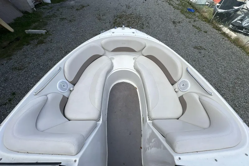 Slide: The Image of 2002 Regal 2400 Bowrider boat interior with white seating and speakers. - 6