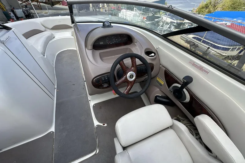 Slide: The Image of 2002 Regal 2400 Bowrider boat interior with steering wheel and seating area. - 9