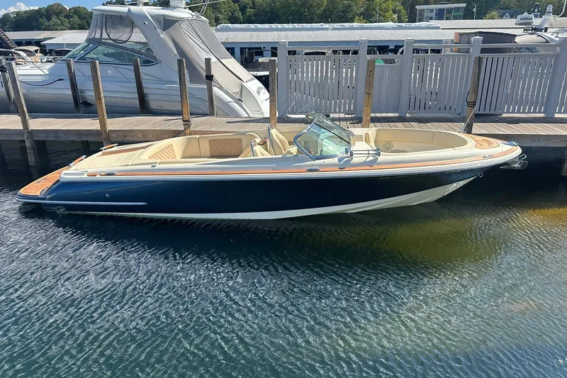 Slide: The Image of 2018 Chris-Craft Launch 27 boat docked in marina, featuring sleek design and luxurious interior. - 1