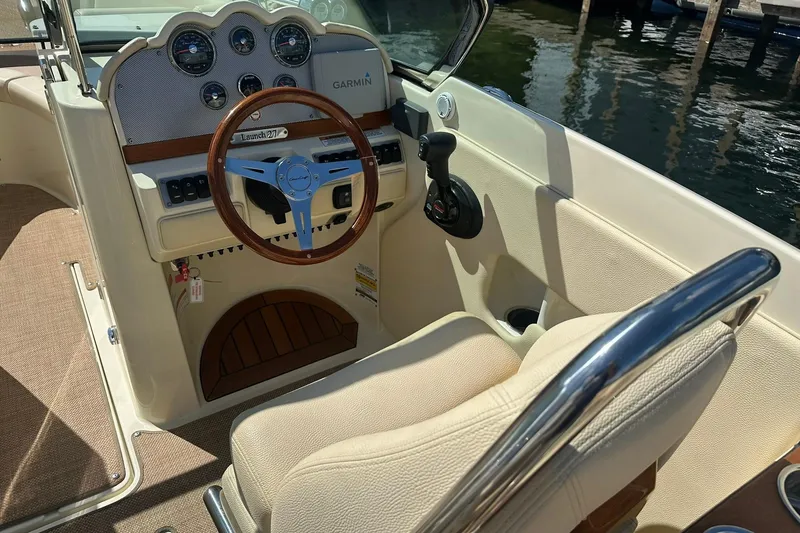 Slide: The Image of 2018 Chris-Craft Launch 27 boat interior with steering wheel and dashboard controls. - 11