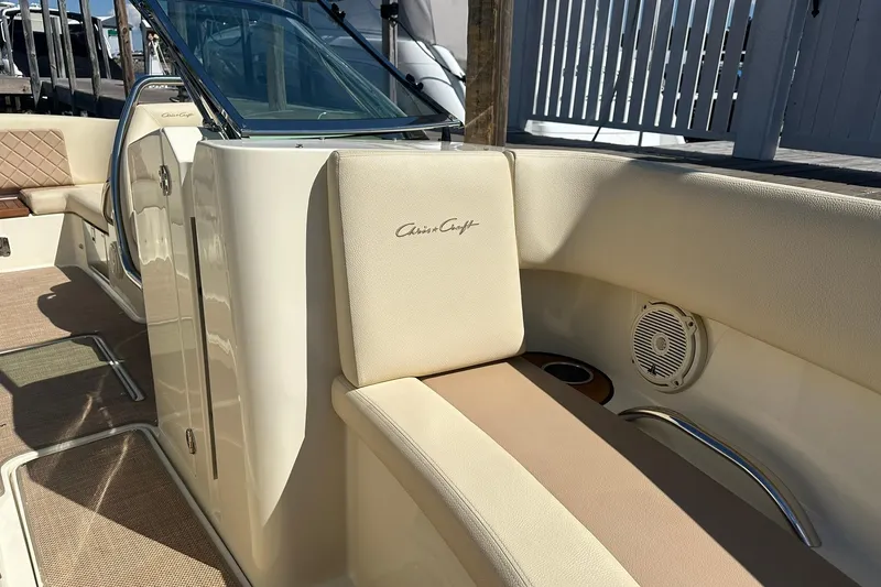 Slide: The Image of 2018 Chris-Craft Launch 27 boat interior with beige seating and speaker detail. - 17