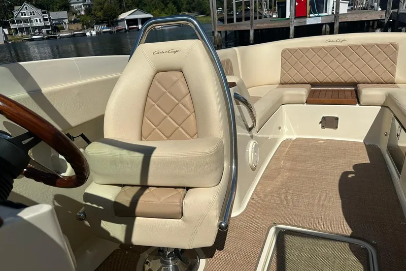 Slide: The Image of 2018 Chris-Craft Launch 27 boat interior with beige leather seating and wooden accents. - 19