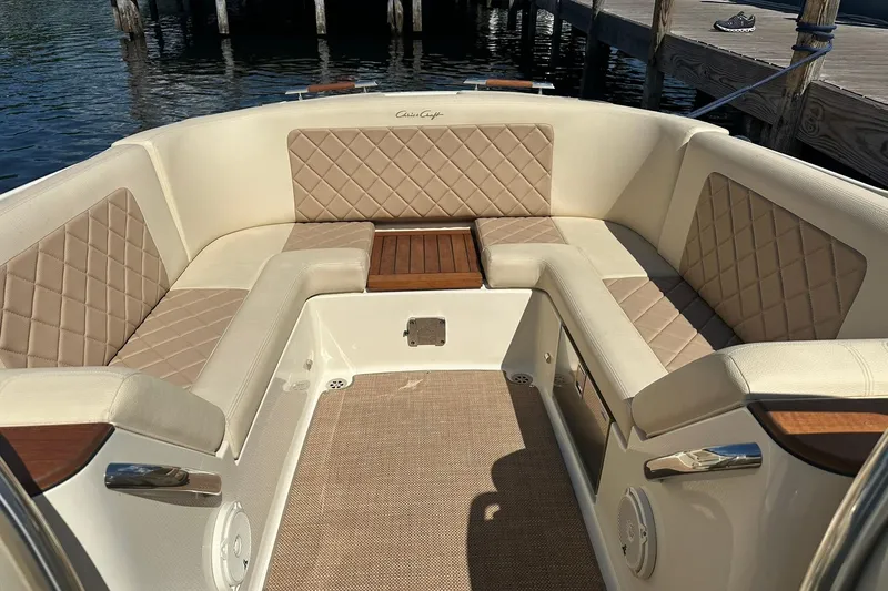 Slide: The Image of 2018 Chris-Craft Launch 27 boat interior with beige diamond-stitched seating and wooden accents. - 22