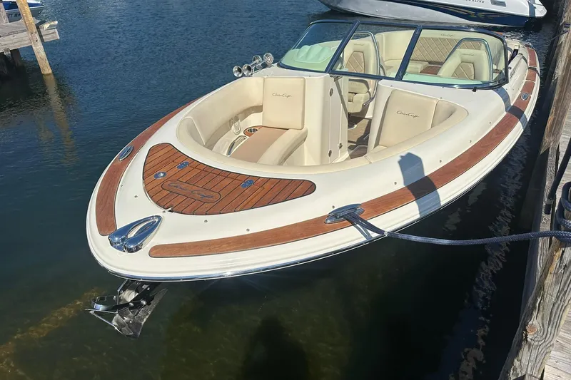 Slide: The Image of 2018 Chris-Craft Launch 27 boat docked, featuring elegant wood accents and spacious seating. - 4
