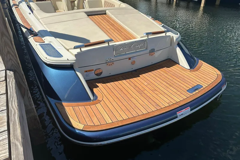 Slide: The Image of 2018 Chris-Craft Launch 27 boat with teak deck, docked in calm water. - 5