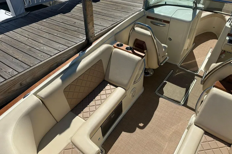 Slide: The Image of 2018 Chris-Craft Launch 27 interior with beige seating and wooden accents at dock. - 8