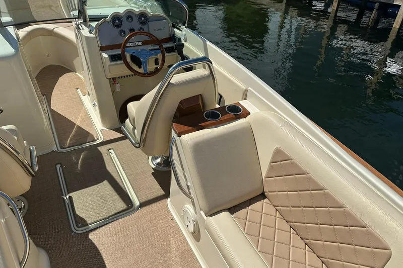 Slide: The Image of 2018 Chris-Craft Launch 27 boat interior with beige seating and wooden accents. - 9