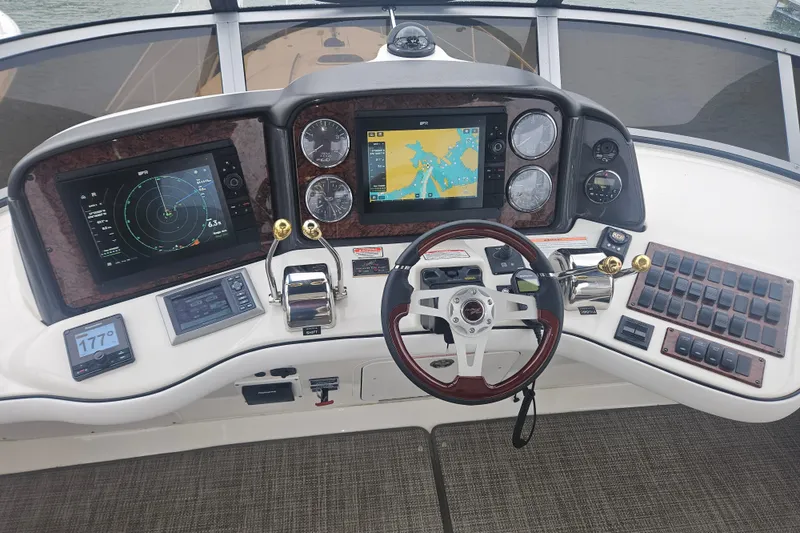 Slide: The Image of 2007 Sea Ray 44 Sedan Bridge helm with navigation screens and controls. - 10