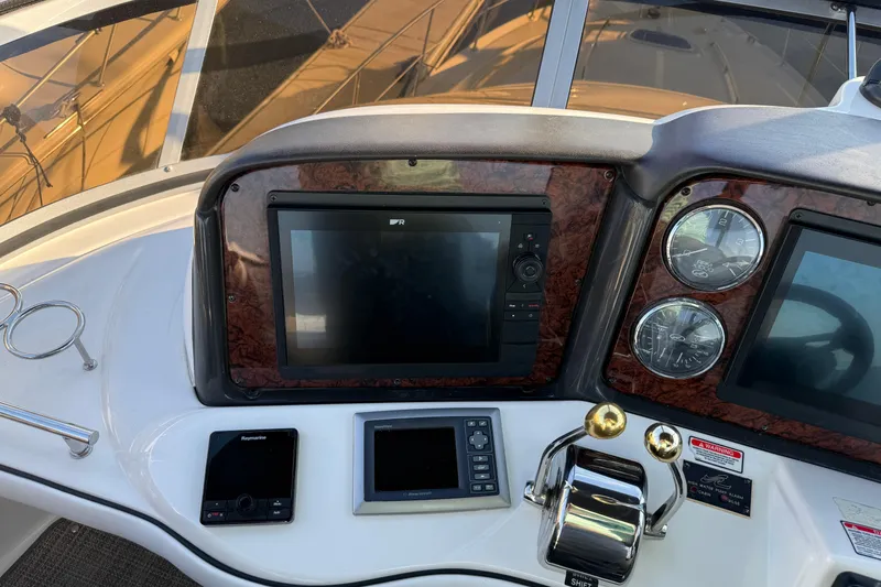 Slide: The Image of 2007 Sea Ray 44 Sedan Bridge helm with navigation screens and controls. - 11