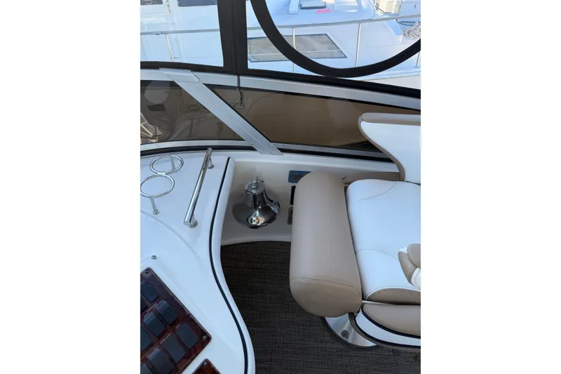 Slide: The Image of 2007 Sea Ray 44 Sedan Bridge helm with beige and white seating. - 19