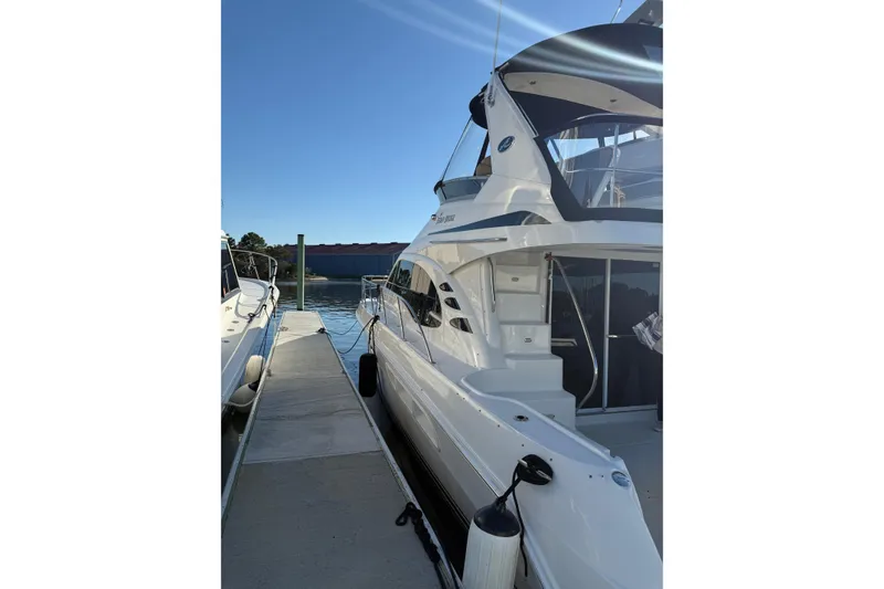 Slide: The Image of 2007 Sea Ray 44 Sedan Bridge yacht docked at marina under clear blue sky. - 2