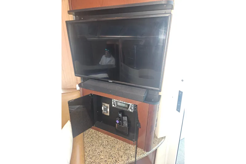 Slide: The Image of Entertainment system inside 2007 Sea Ray 44 Sedan Bridge yacht, featuring a Vizio TV and control panel. - 32