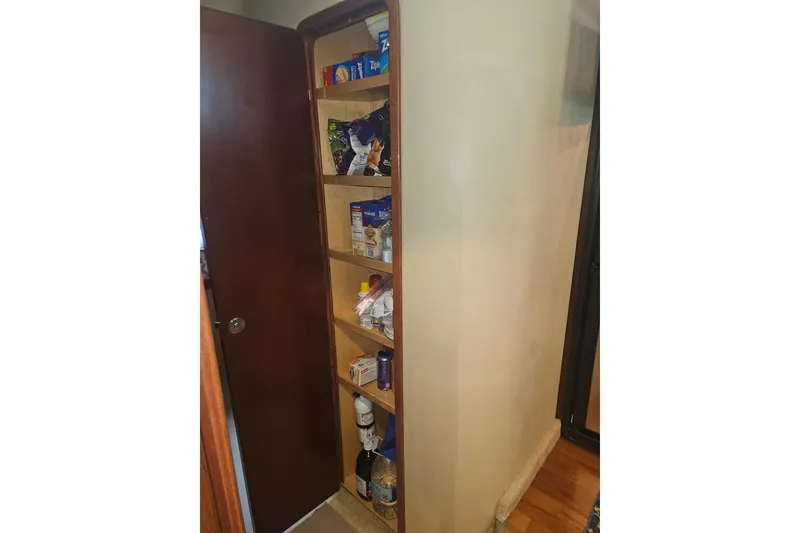 Slide: The Image of Pantry shelves inside a 2007 Sea Ray 44 Sedan Bridge, stocked with various food items. - 39
