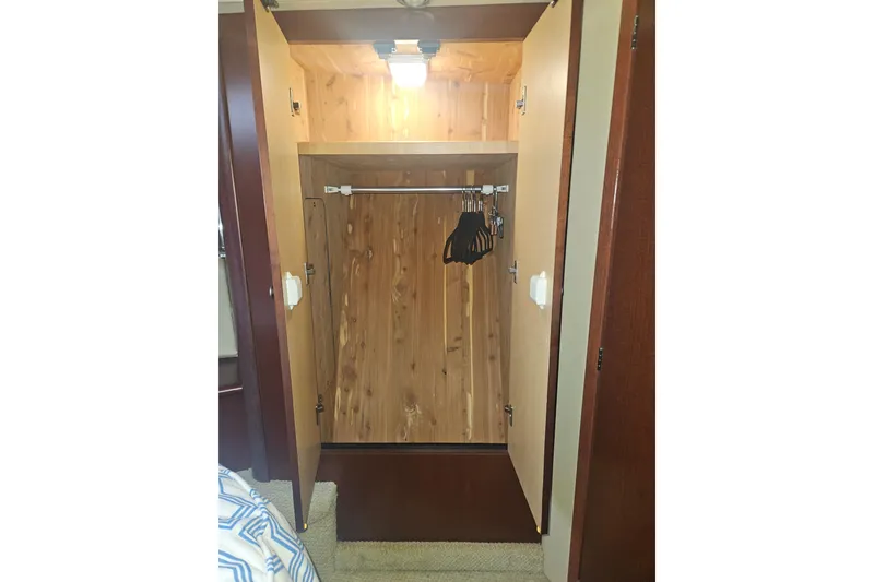 Slide: The Image of Open wooden closet with hangers inside a 2007 Sea Ray 44 Sedan Bridge yacht. - 44
