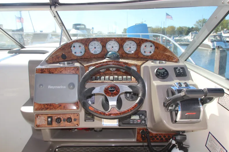 Slide: The Image of 2006 Rinker 320 Express Cruiser dashboard with steering wheel and navigation controls. - 12
