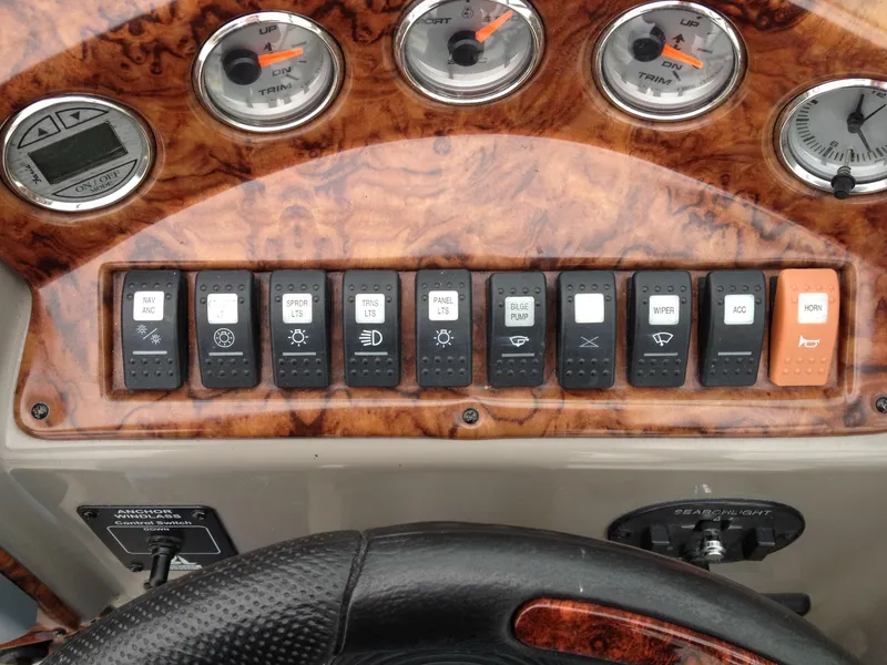 Slide: The Image of Control panel of a 2006 Rinker 320 Express Cruiser with various switches and gauges. - 13