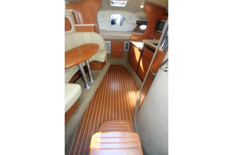 Slide: The Image of 2006 Rinker 320 Express Cruiser interior with wood flooring and cozy seating area. - 22