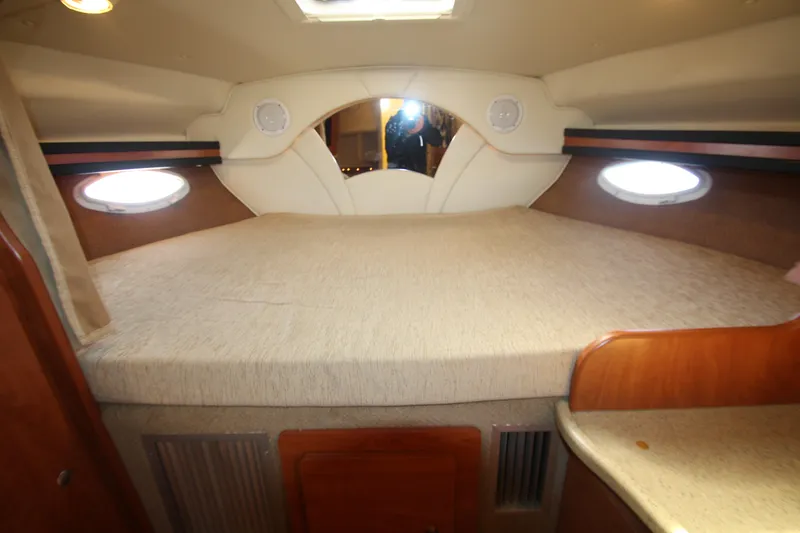 Slide: The Image of 2006 Rinker 320 Express Cruiser cabin interior with bed and portholes. - 27