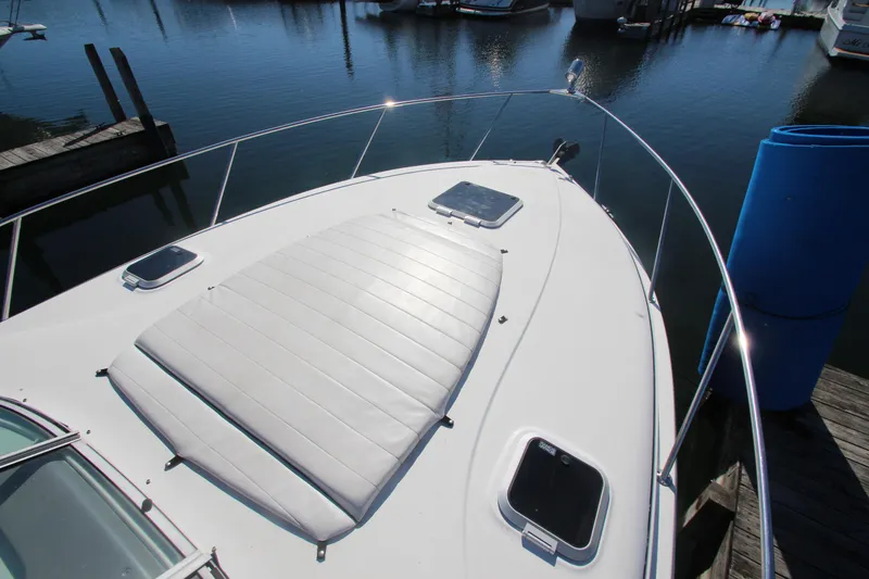 Slide: The Image of 2006 Rinker 320 Express Cruiser boat deck with sun pad, docked in marina. - 3