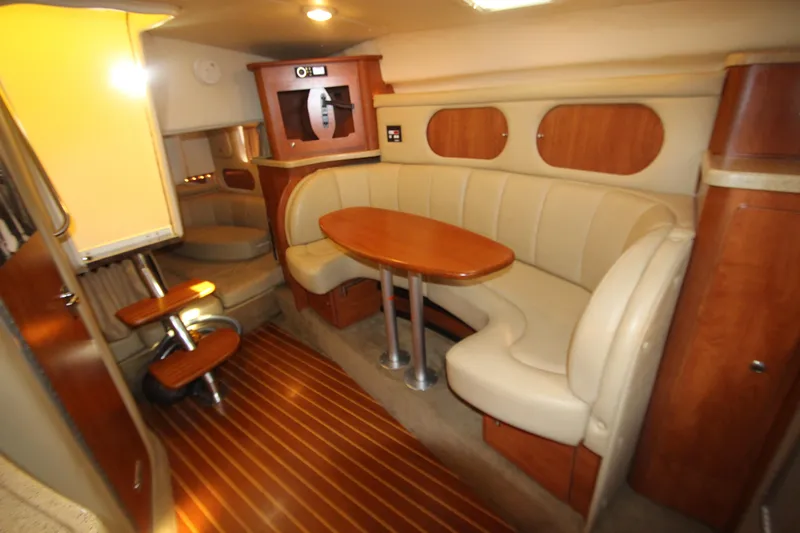 Slide: The Image of 2006 Rinker 320 Express Cruiser interior with beige seating and wooden accents. - 32