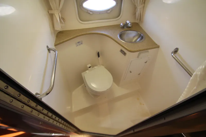 Slide: The Image of 2006 Rinker 320 Express Cruiser bathroom with toilet, sink, and porthole window. - 35