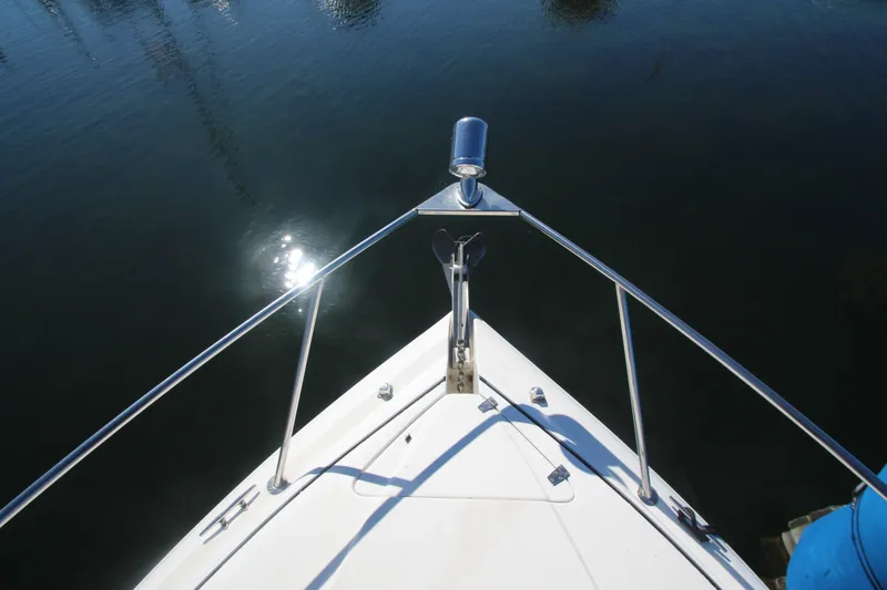 Slide: The Image of Bow view of 2006 Rinker 320 Express Cruiser on calm water. - 4