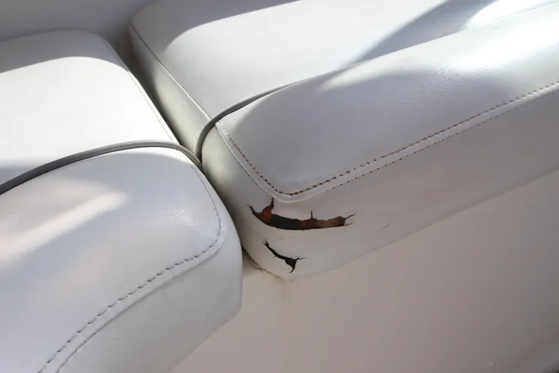 Slide: The Image of 2006 Rinker 320 Express Cruiser seat with visible tear and wear. - 8