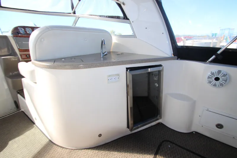 Slide: The Image of 2006 Rinker 320 Express Cruiser interior with kitchenette and mini fridge. - 9
