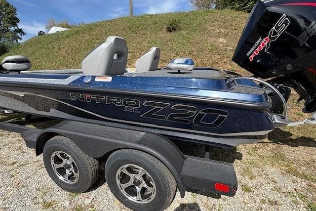 The Image of 2026 Nitro Z20 XL boat on trailer, parked on gravel near grassy hill. - 0