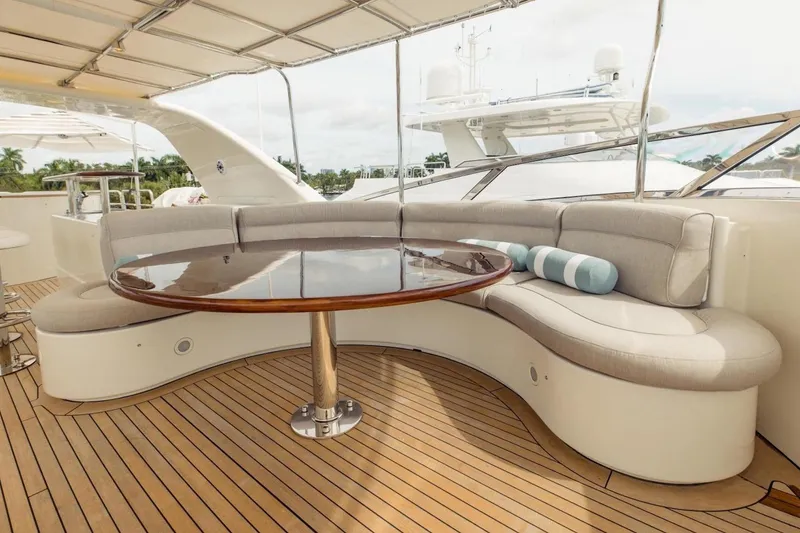 Slide: The Image of Luxurious seating area on 2007 Benetti 120 Classic yacht with wooden table and cushions. - 17