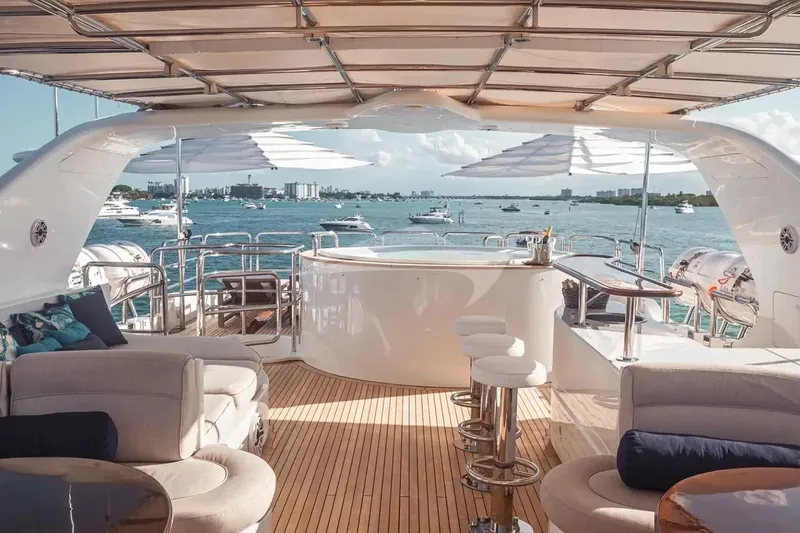 Slide: The Image of Luxurious 2007 Benetti 120 Classic yacht deck with seating, bar, and ocean view. - 19