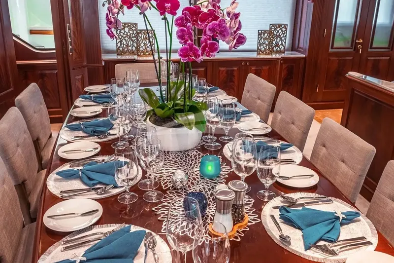 Slide: The Image of Luxurious dining setup on a 2007 Benetti 120 Classic yacht, featuring elegant tableware and orchids. - 28