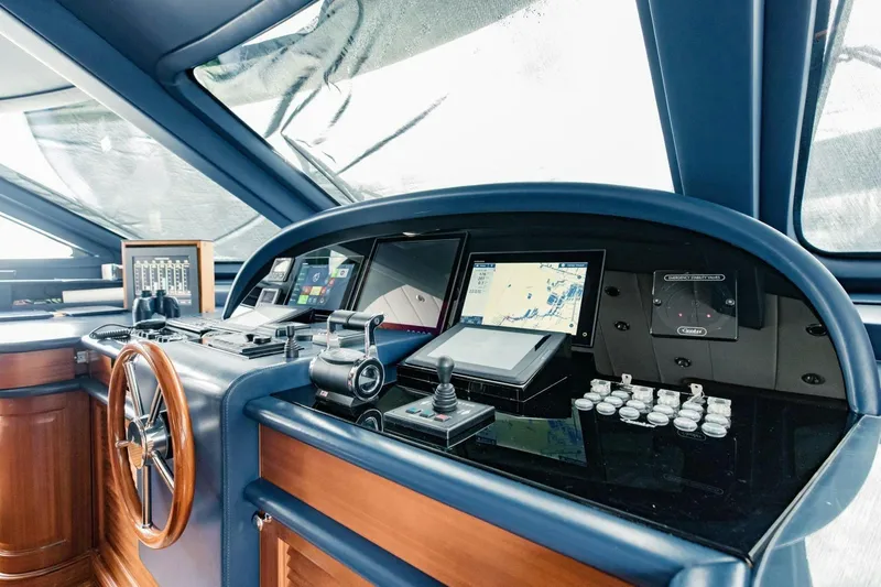 Slide: The Image of Control panel of a 2007 Benetti 120 Classic yacht, featuring navigation instruments and steering wheel. - 46