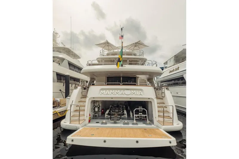 Slide: The Image of Luxury yacht Benetti 120 Classic, 2007 model, docked with open garage and flag display. - 5